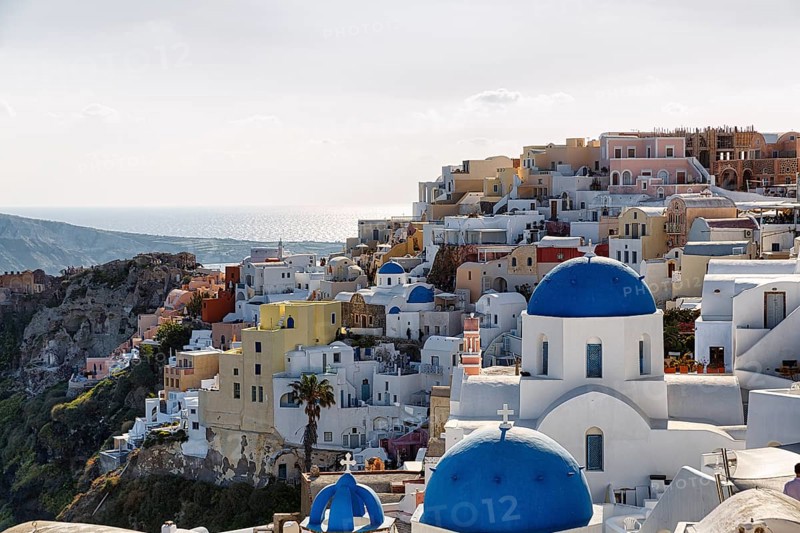 Typical architecture with white or colourfully whitewashed holiday homes and blue roofs, churches on the edge of the caldera, Oia, Thira, Santorini, Cyclades, Greece