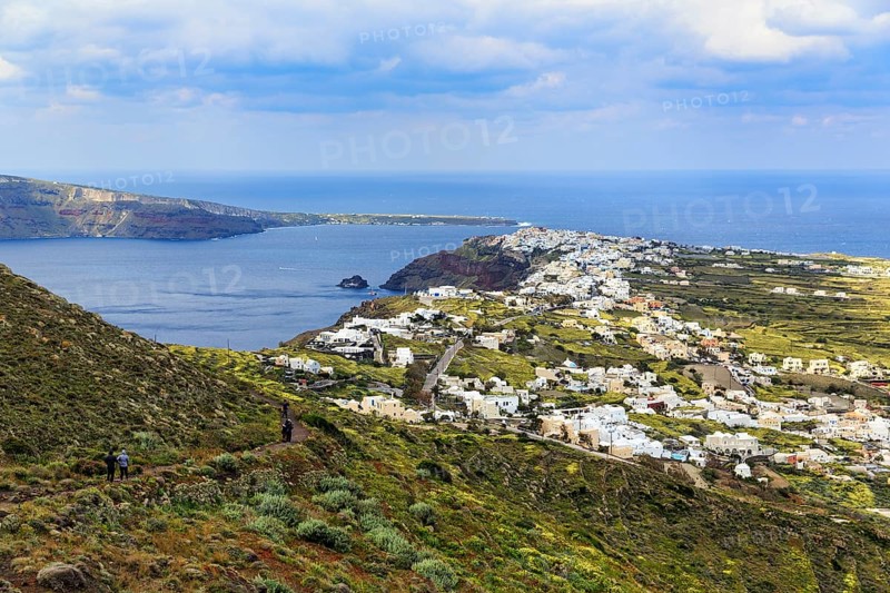 Coastline with view of the village of Oia, hiker on hiking trail from Fira to Oia, Thira, Santorini, Cyclades, Greece