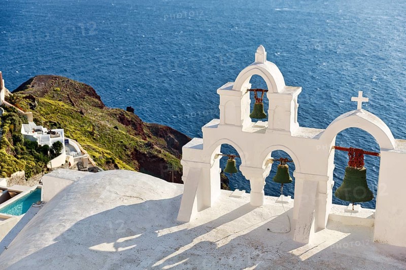 White bell tower of an orthodox church overlooking the sea, coastline, Oia, Santorini, Cyclades, Aegean Sea, Greece