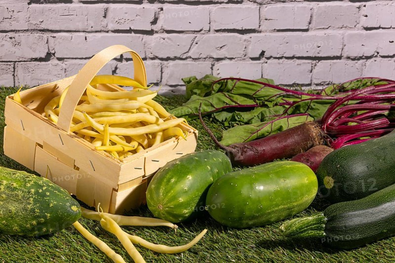 Vegetable mix of yellow beans, beetroot, cucumber and courgette on green grass