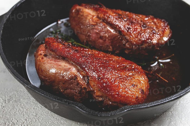 Roast duck breast, in a frying pan, with spices and herbs, close-up, no people