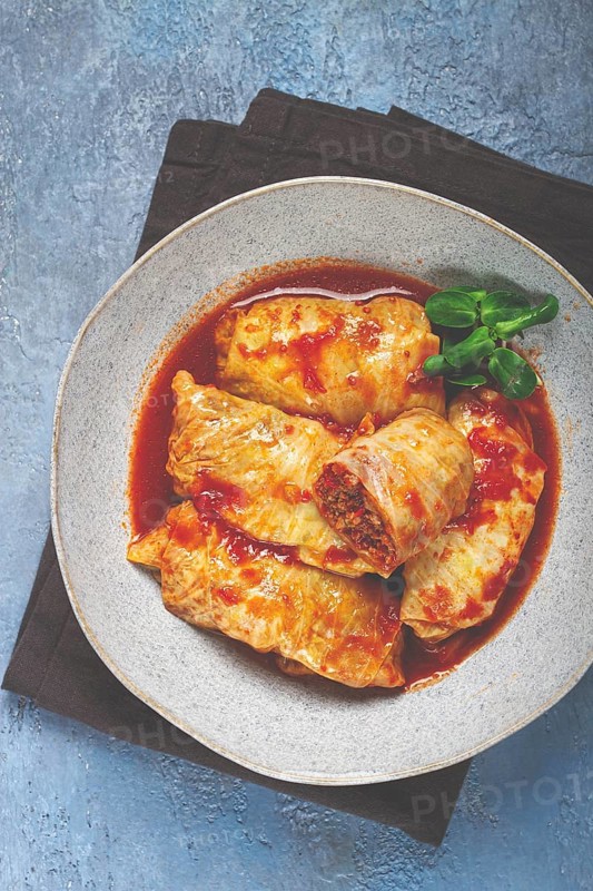 Stuffed cabbage rolls with minced meat, in tomato sauce, top view, without people, in the spotlight
