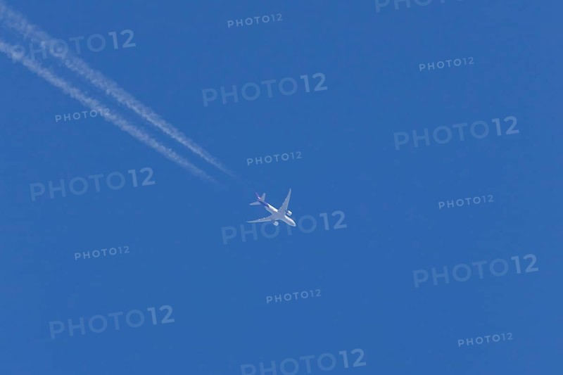 Airbus A300-600RF jet aircraft of FedEx Express airlines in flight in a blue sky with vapour trails or contrails behind, England, United Kingdom