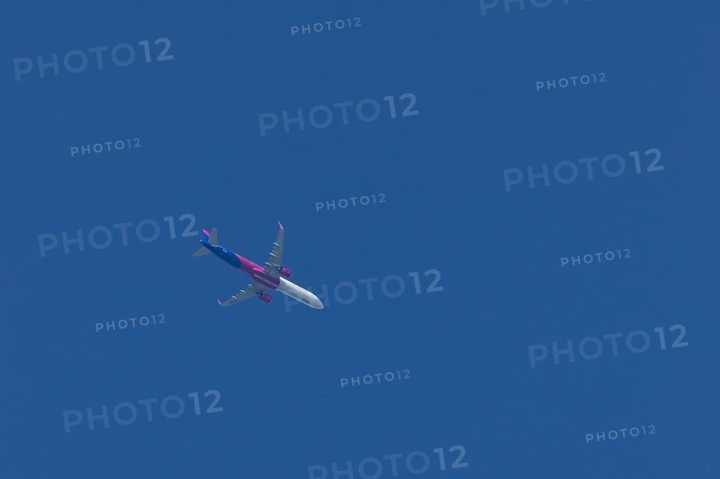 Airbus A321 jet aircraft of Wizz Air airlines in flight in a blue sky, England, United Kingdom