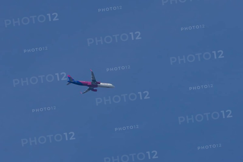 Airbus A321 jet aircraft of Wizz Air airlines in flight in a blue sky, England, United Kingdom