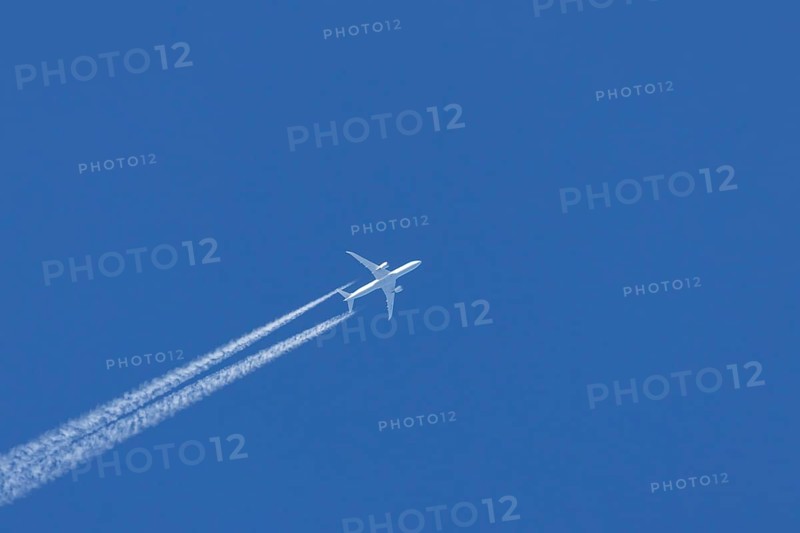 Boeing 787-9 Dreamliner jet passenger aircraft of KLM Royal Dutch airlines in flight in a blue sky with vapour trails or contrails behind, England, United Kingdom