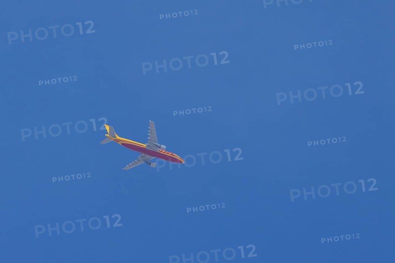 Boeing 767 jet aircraft of DHL cargo airlines in flight in a blue sky, England, United Kingdom