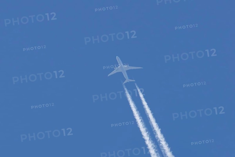 Boeing 787-9 Dreamliner jet passenger aircraft of KLM Royal Dutch airlines in flight in a blue sky with vapour trails or contrails behind, England, United Kingdom