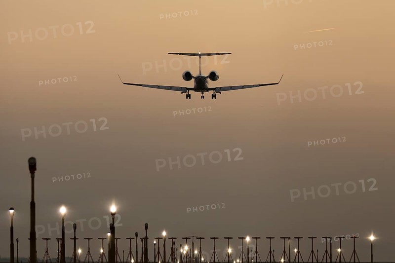 Bombardier Global business jet passenger aircraft in flight landing at sunset at London Stansted airport, Essex, England, United Kingdom