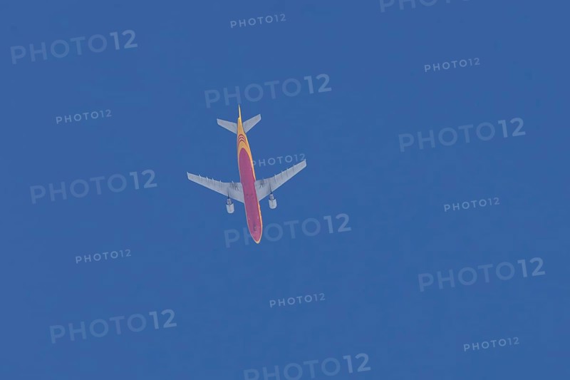 Boeing 767 jet aircraft of DHL cargo airlines in flight in a blue sky, England, United Kingdom