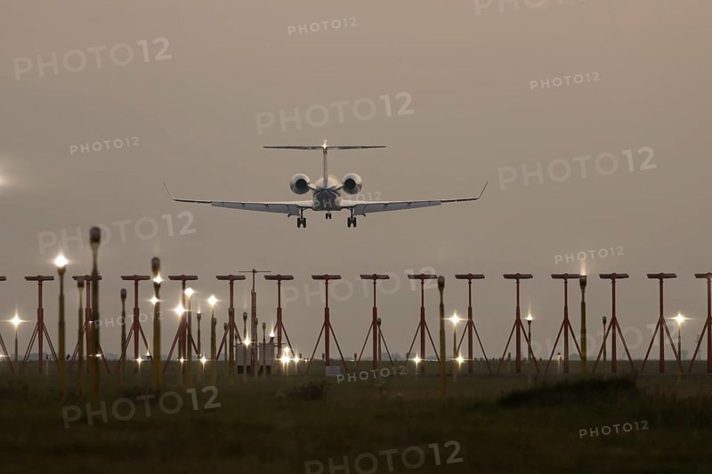 Bombardier Global business jet passenger aircraft in flight landing at sunset at London Stansted airport, Essex, England, United Kingdom