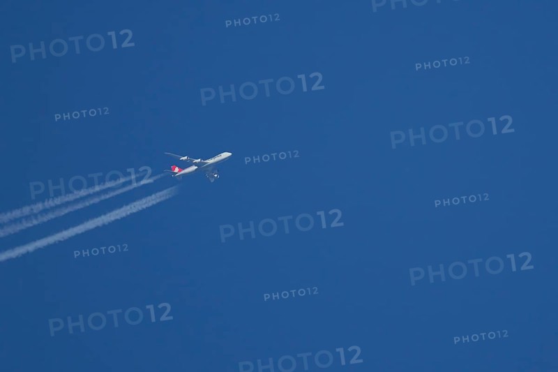 Boeing 747 Jumbo jet cargo aircraft of Cargolux airlines in flight in a blue sky with vapour trails or contrails behind, England, United Kingdom