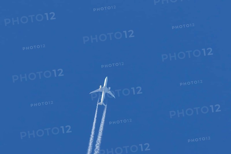 Boeing 787-9 Dreamliner jet passenger aircraft of KLM Royal Dutch airlines in flight in a blue sky with vapour trails or contrails behind, England, United Kingdom