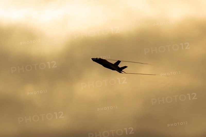 Lockheed Martin F-35 Lightning II fighter military aircraft of the United States air force USAF silhouette in flight at sunset at RAF Lakenheath airbase, Suffolk, England, United Kingdom