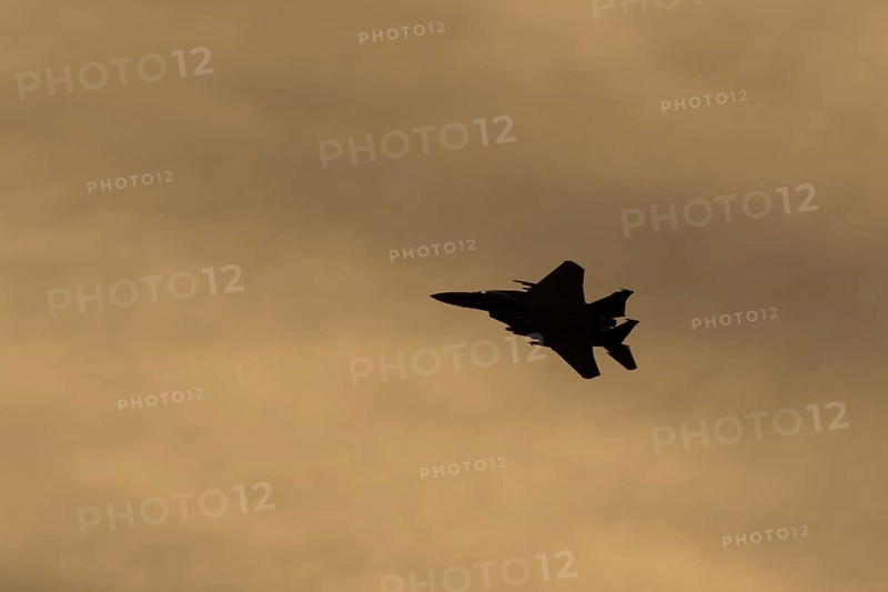 McDonnell Douglas F-15E Strike Eagle fighter military aircraft of the United States air force USAF in flight silhouette at sunset at RAF Lakenheath airbase, Suffolk, England, United Kingdom
