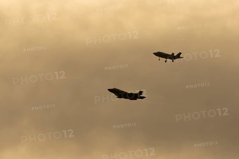 Lockheed Martin F-35 Lightning II fighter two military aircraft of the United States air force USAF silhouette in flight at sunset at RAF Lakenheath airbase, Suffolk, England, United Kingdom