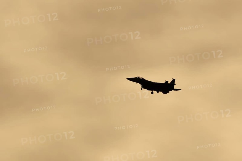 McDonnell Douglas F-15E Strike Eagle fighter military aircraft of the United States air force USAF in flight silhouette at sunset at RAF Lakenheath airbase, Suffolk, England, United Kingdom