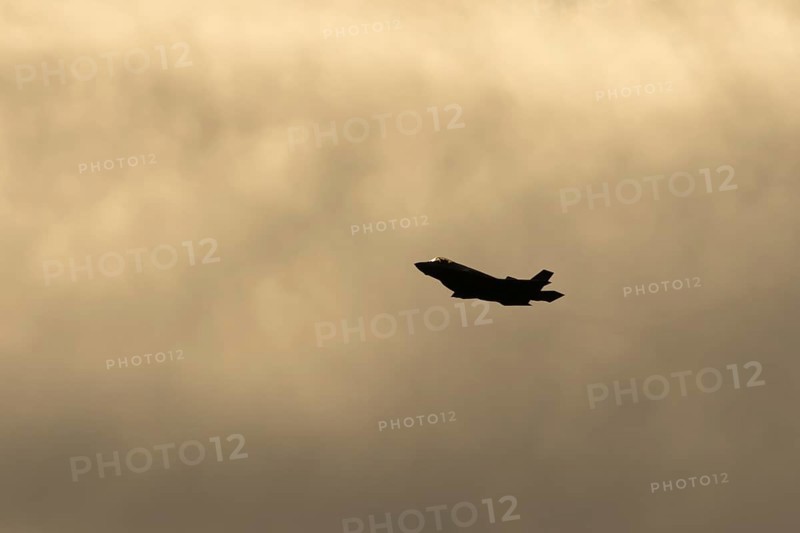 Lockheed Martin F-35 Lightning II fighter military aircraft of the United States air force USAF silhouette in flight at sunset at RAF Lakenheath airbase, Suffolk, England, United Kingdom