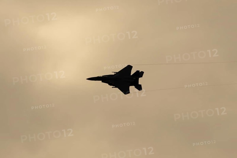 McDonnell Douglas F-15E Strike Eagle fighter military aircraft of the United States air force USAF in flight silhouette at sunset at RAF Lakenheath airbase, Suffolk, England, United Kingdom