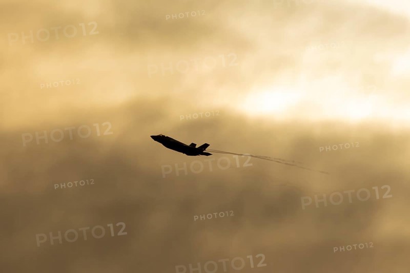 Lockheed Martin F-35 Lightning II fighter military aircraft of the United States air force USAF silhouette in flight at sunset at RAF Lakenheath airbase, Suffolk, England, United Kingdom