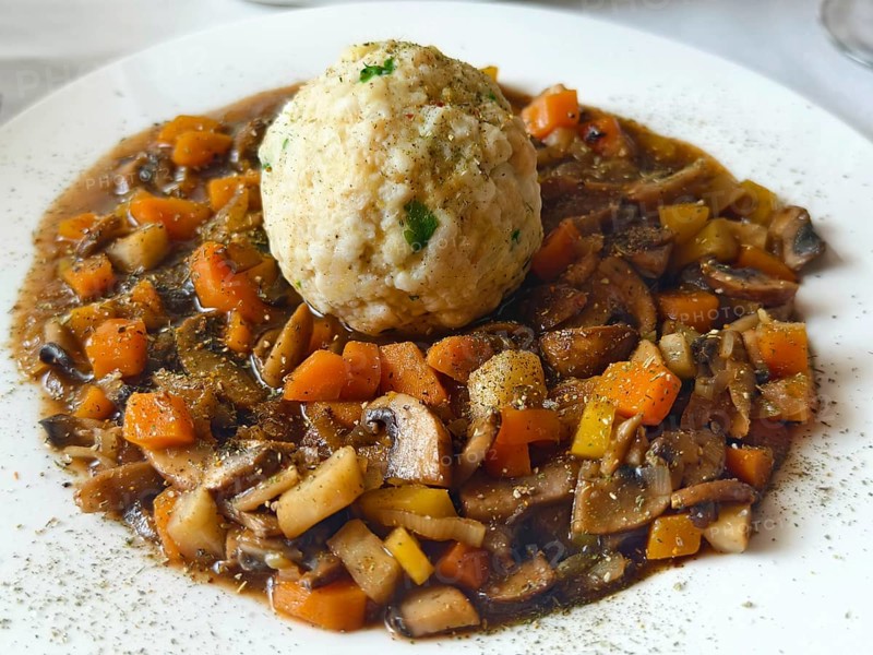 Vegetable stew with mushrooms and bread dumplings on a white plate, seasoned and served Lower Austria Austria