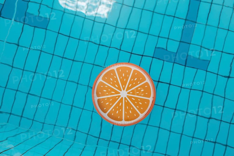 Blue swimming pool from above, an orange tray floats in it