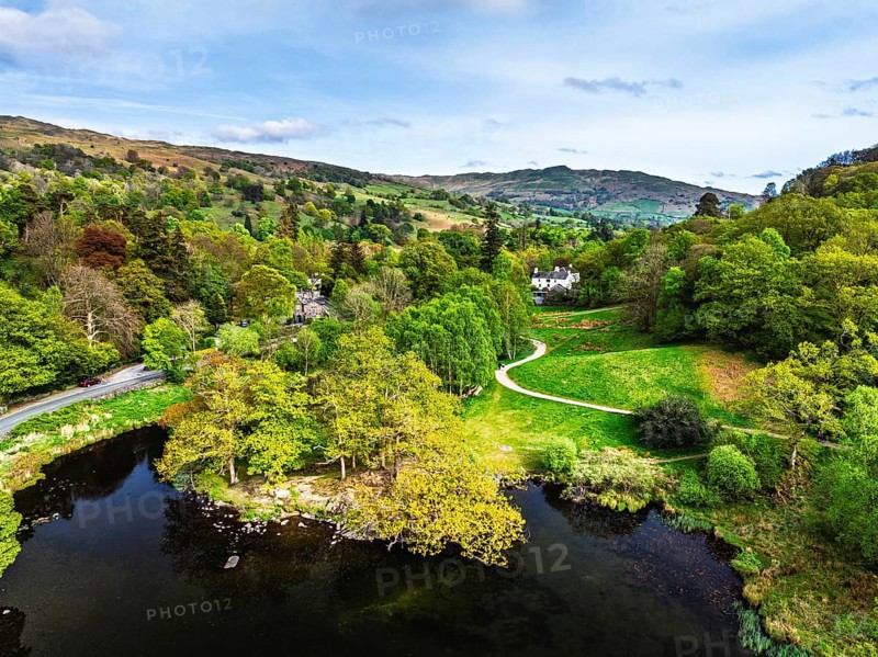 Farms and Mountains over road A591 from a drone, Grasmere Lake, Grasmere, Ambleside, Lake District, Westmorland, Cumbria, UK