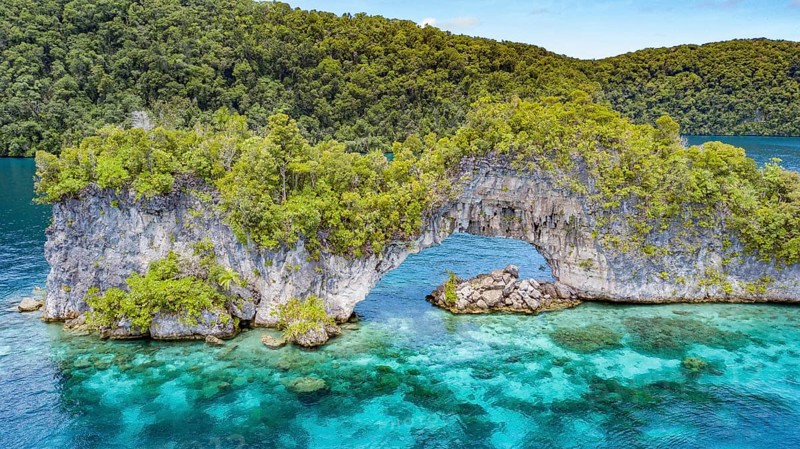 Aerial view bird's eye view through rock arch Natural Arch in lagoon of island paradise island state Palau in the Pacific West Pacific, Rock Islands, Republic of Palau, Micronesia, Australia, Oceania