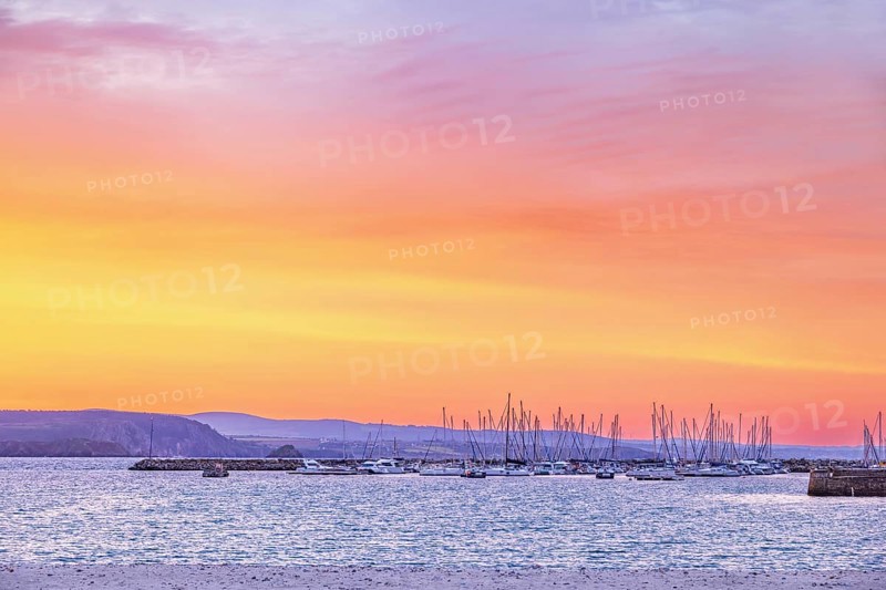 Marina with pleasure boats at a beautiful sunset over the sea and the rocky coastline a summer evening, Crozon peninsula, Bretagne, France
