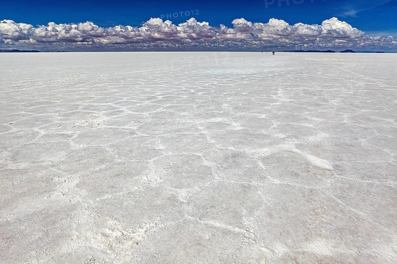 Salt crust with hexagonal patterns under a sky full of clouds, conveying endless expanses, The endless expanses of the salt plain of the Salar de Uyuni in Bolivia