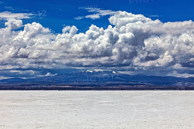 Scenic salt flat with dramatic clouds and distant mountain peaks on the horizon, The endless expanses of the salt plain of the Salar de Uyuni in Bolivia