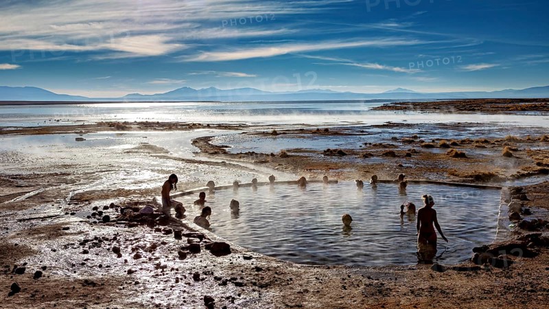 People bathe in hot springs with views of mountains and vast skies, The thermal springs of Polques in Bolivia