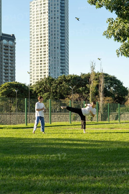 Young martial artists practicing Taekwondo outdoors at sunset