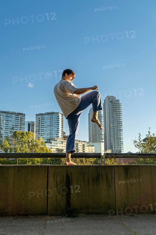 Young martial artist performing the crane pose in a modern city