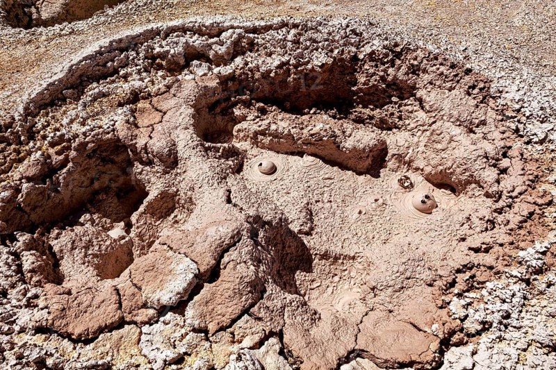 Red, cracked crater with muddy bubbles in a barren environment, The mud volcanoes and fumaroles on the Altiplano in Bolivia
