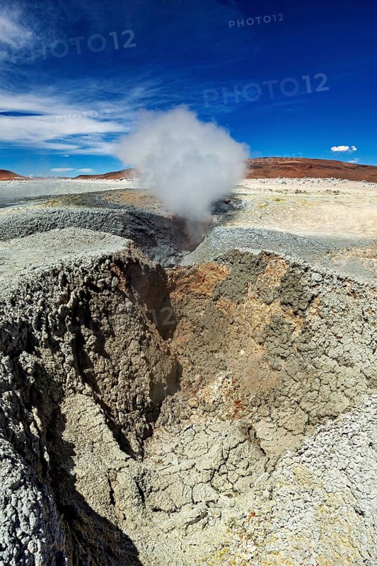 Large crater with steaming geyser in a rocky desert landscape, The mud volcanoes and fumaroles on the Altiplano in Bolivia