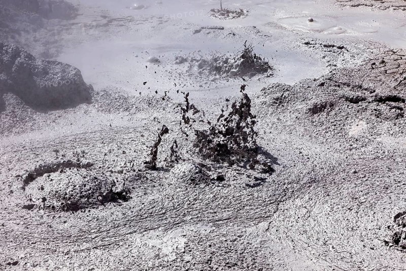 Bubbling mud erupts in a dark geothermal environment, The mud volcanoes and fumaroles on the Altiplano in Bolivia