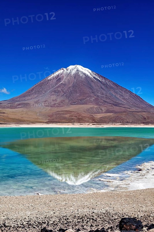 Striking volcano with a turquoise lake whose clear surface reflects the majestic mountain, The Laguna Colorada in Bolivia
