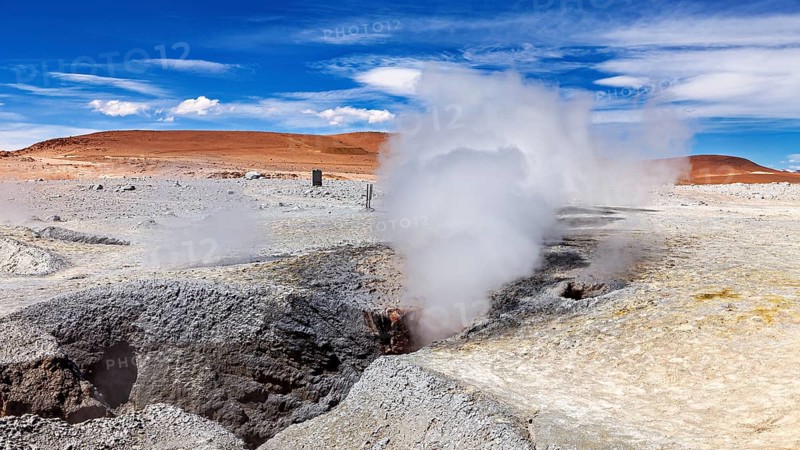 Steam rises from geysers in a rocky desert landscape, sweeping views into the distance, The mud volcanoes and fumaroles on the Altiplano in Bolivia