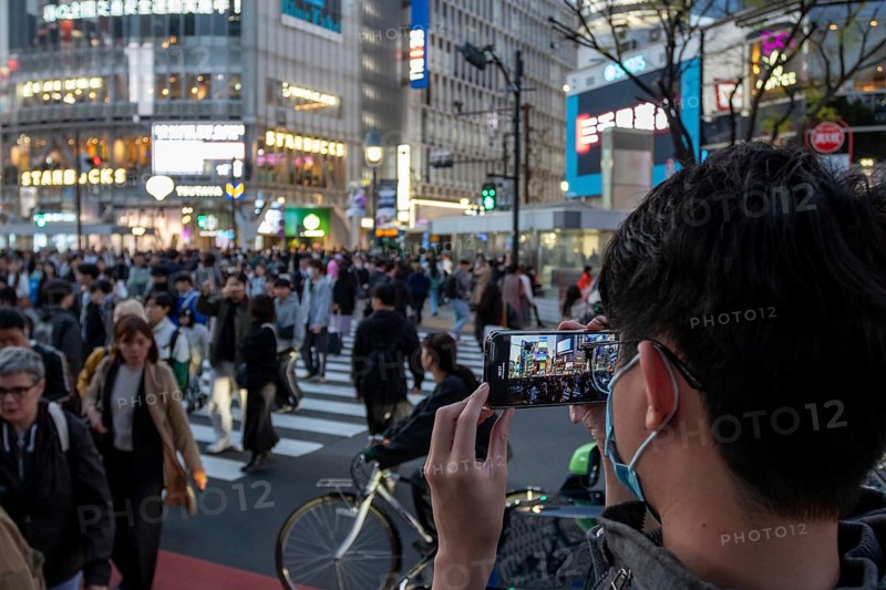 A tourist films the crowd at the zebra crossing of Shibuya Crossing with his smartphone, world-famous crossing in the Shibuya district, tourist attraction, sight, Shibuya district, Tokyo, Japan