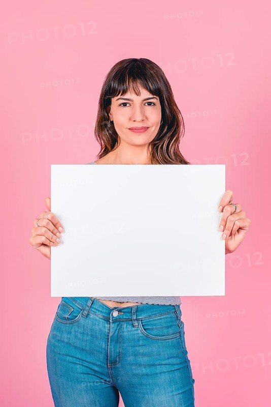 Smiling woman holding a blank sign with copy space for breast cancer awareness