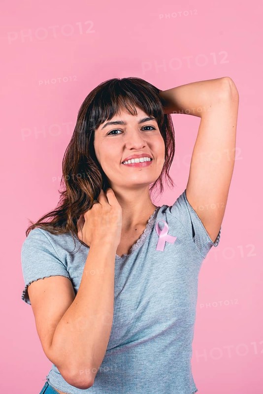 Happy young woman supporting breast cancer awareness with pink ribbon