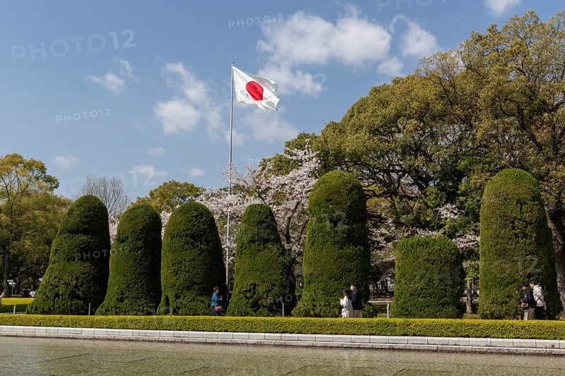 Japanese national flag and artistically trimmed hedges in the Peace Park, sight, UNESCO World Heritage Site, peace memorial and memorial to the victims of the atomic bombing of Hiroshima, Naka Ward, Hiroshima, Japan