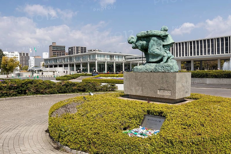 Statue of mother and children in the storm, bronze statue by the artist Shin Hongo in front of the Hiroshima Peace Museum, landmark, UNESCO World Heritage Site, peace memorial and memorial to the victims of the atomic bombing of Hiroshima in the Peace Park, Naka Ward, Hiroshima, Japan