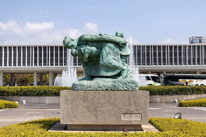 Statue of mother and children in the storm, bronze statue by the artist Shin Hongo in front of the Hiroshima Peace Museum, landmark, UNESCO World Heritage Site, peace memorial and memorial to the victims of the atomic bombing of Hiroshima in the Peace Park, Naka Ward, Hiroshima, Japan
