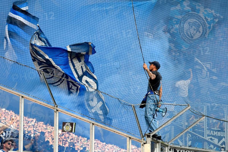 Borussia Park Mönchengladbach, 24.8.2025 Football: Bundesliga Season 2025/26 1st Matchday, Borussia Mönchengladbach (BMG, white) vs Hamburger Sportverein (HSV, blue) _ Pre-singer and Ultra HSV Fans in the guest fan block in blue smoke _ DFL REGULATIONS PROHIBIT ANY USE OF PHOTOGRAPHS AS IMAGE SEQUENCES AND/OR QUASI-VIDEO