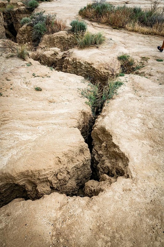 Cracks in arid soil reveal changes caused by erosion, in bardenas reales in spain, highlighting the natural dry landscape, The image signifies geological natural formations and earth's changing terrain due to environmental factors in bardenas reales, spain