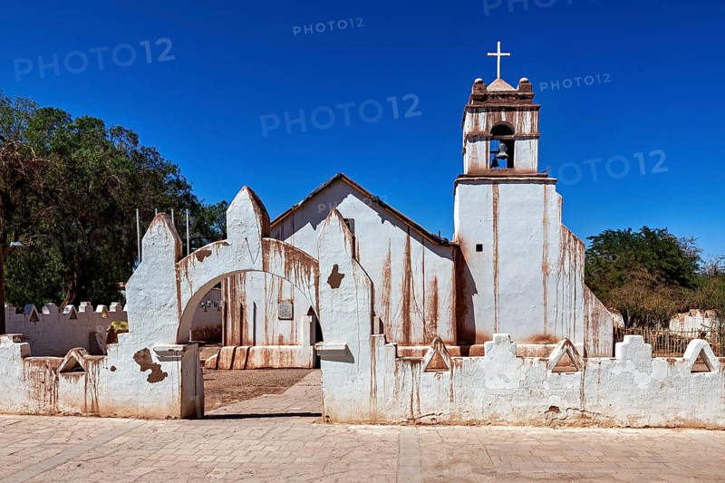 Rustic church with a striking cross under a bright blue sky and clear lines, The church of San Pedro de Atacama in Chile