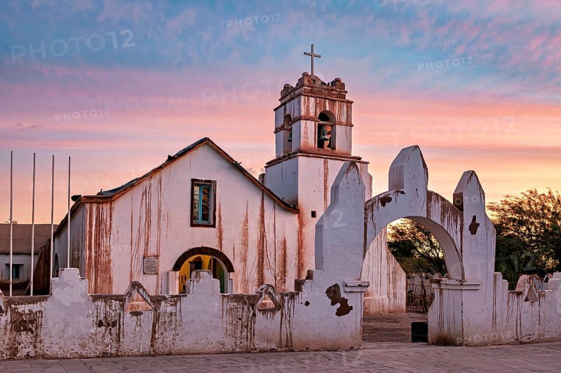 Church at sunset, warm colour palette with illuminated sky and cross tower, The church of San Pedro de Atacama in Chile
