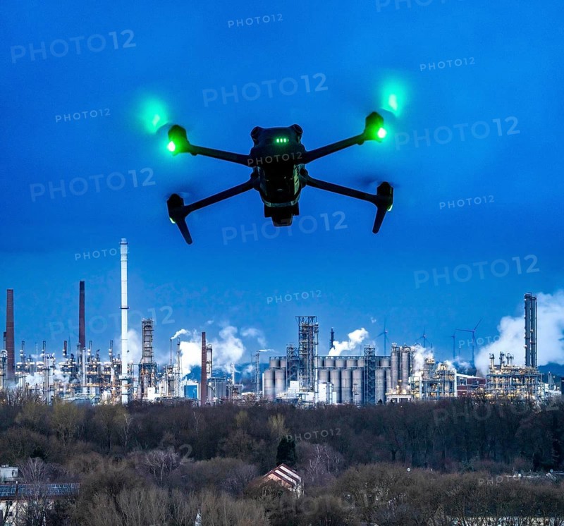 Symbolic image, photomontage, reconnaissance, spying with drones in industrial plants, critical infrastructure, drone flies towards an industrial complex, chemical plant, spying by camera drones